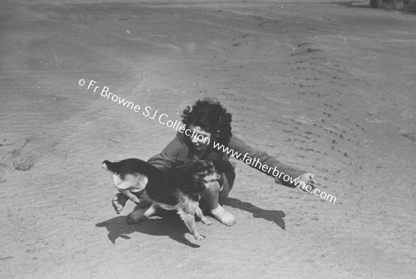 GIRL PLAYING WITH DOG ON BEACH